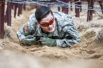 U.S. Army Sgt. Curtis Presley crawls under a barbed-wire obstacle during the obstacle course portion of the 80th Training Command and 99th Regional Support Command’s combined Best Warrior Competition April 5, 2017.