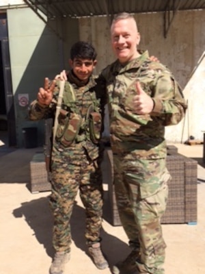 Army Command Sgt. Maj. John Wayne Troxell, the senior enlisted advisor to the chairman of the Joint Chiefs of Staff, poses with a young Syrian Democratic Forces soldier near Kobani, Syria, April 4, 2017. 