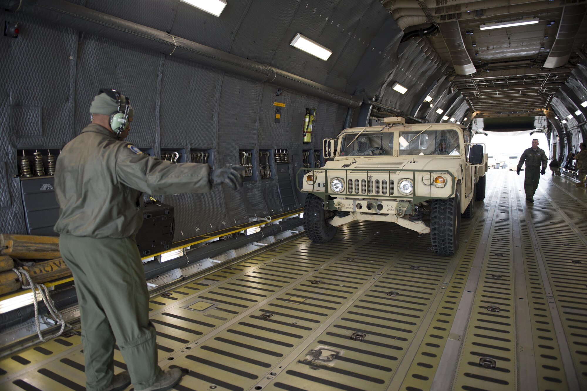 Senior Master Sgt. Bernard London, 709th Airlift Squadron, directs a Humvee onto a C-5M Super Galaxy during a joint emergency deployment exercise focusing on loading and unloading procedures of personnel and their equipment, Joint Base Langley-Eustis, March 18, 2017. (U.S. Air Force photo/ Tech. Sgt. Mercedes Crossland)