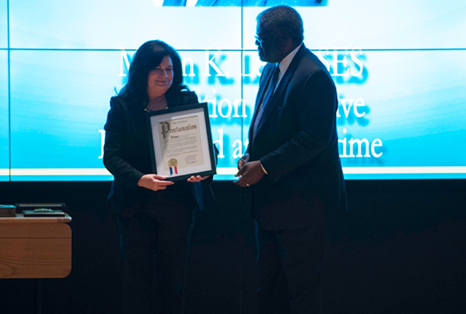 Milton Lewis, Acquisition Executive at DLA Land and Maritime, receives Whitehall Proclamation from Mayor Kim Maggard at a March 31 retirement ceremony.