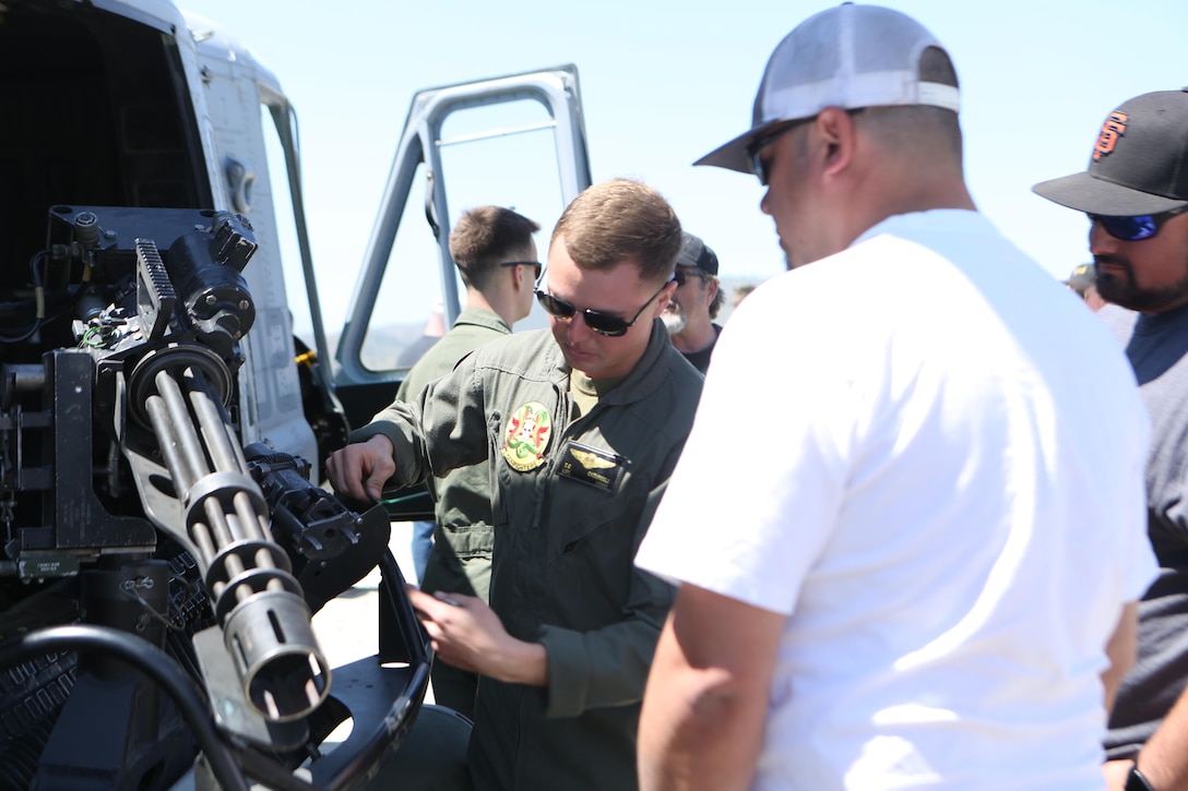 A crew chief with Marine Light Attack Helicopter Squadron (HMLA) 369 "Gunfighters" demonstrates how an M134 minigun functions during the squadron’s 45th anniversary celebration and family day on Marine Corps Base Camp Pendleton, Calif., April 1. The family day included static displays of an AH-1Z Viper and a UH-1Y Huey and a live-fire demonstration. (U.S. Marine Corps photo by Lance Cpl. Liah Kitchen/Released)