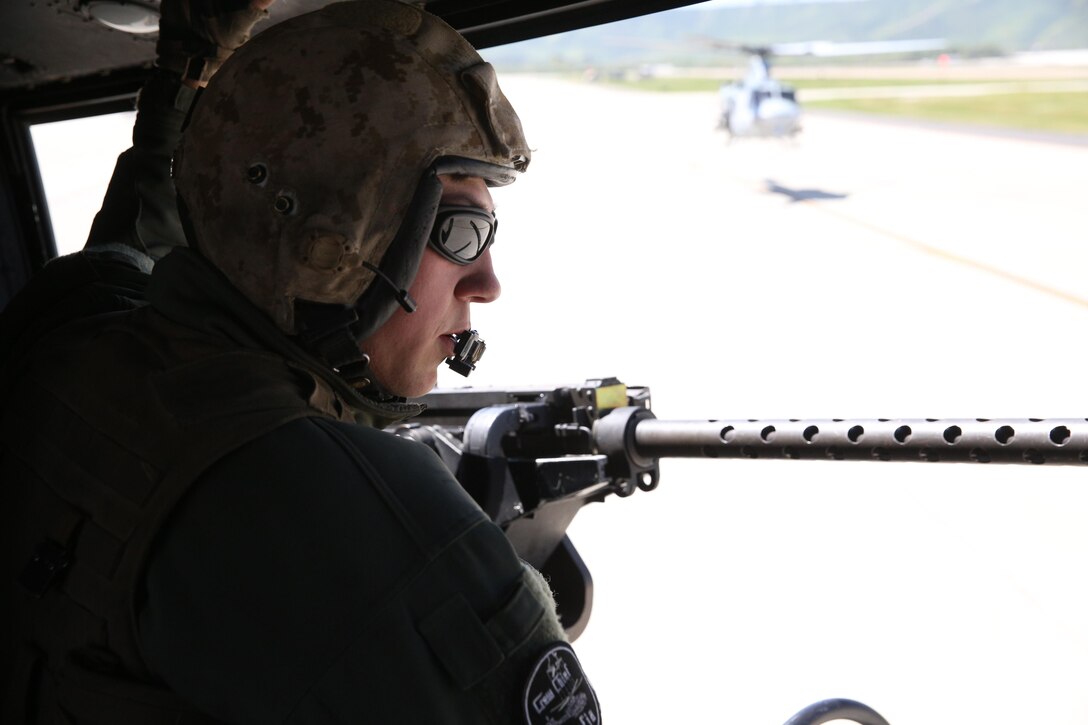 A crew chief with Marine Light Attack Helicopter Squadron (HMLA) 369 “Gunfighters” communicates with pilots during a live-fire demonstration on Marine Corps Base Camp Pendleton, Calif., April 1. The unit conducted the demonstration as a part of HMLA-369’s 45th Anniversary celebration and family day. (U.S. Marine Corps photo by Lance Cpl. Jake M.T. McClung/Released)