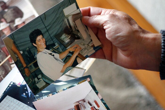 Iowa Army National Guard Chief Warrant Officer 5 Marty Hupp, of Grimes, Iowa, sorts through photographs from her 40-year military career in light of her upcoming retirement. Iowa National Guard photo by Army Sgt. Christie Smith