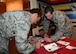 Airman 1st Class Caleb Fritsch, an air traffic controller assigned to the 28th Operations Support Squadron, assists Capt. Kyle Moyer, the operations compliance officer in charge assigned to the 28th Logistics Readiness Squadron, in donating to the Air Force Assistance Fund in the Dakota’s Cub at Ellsworth Air Force Base, S.D., March 31, 2017. The AFAF consists of four charities including the Air Force Aid Society, the Air Force Enlisted Village, the Air Force Villages Indigent Widows' Fund, and the General and Mrs. Curtis E. LeMay Foundation. (U.S. Air Force photo by Airman 1st Class Donald C. Knechtel)