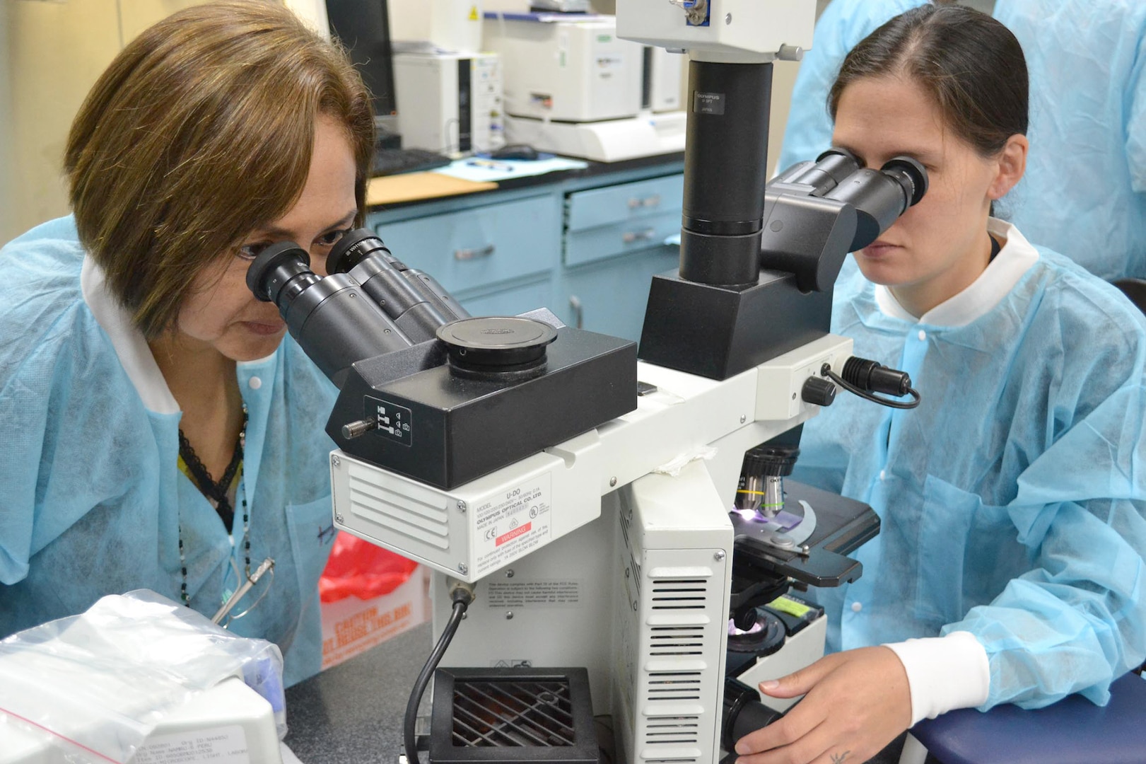 Navy Lt. Kimberly Edgel (right) and Carmen Lucas examine a positive malaria blood smear at U.S. Naval Medical Research Unit, or NAMRU, 6 in Callao, Peru. NAMRU-6 studies malaria infection, diagnosis and treatment and is the only U.S. command in South America. 