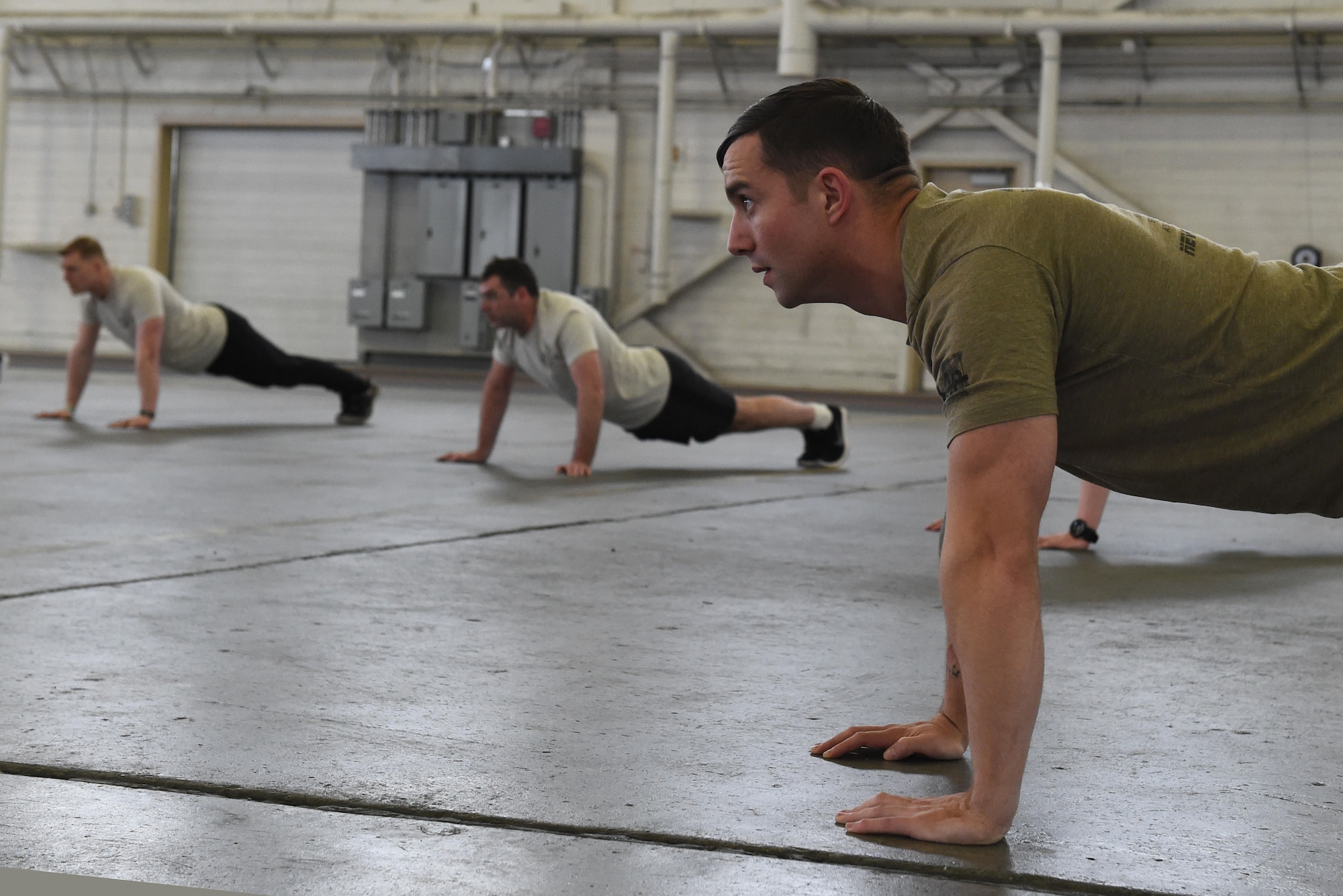 Members of the 3rd Air Support Operations Squadron do push-ups during a memorial ceremony after the annual 24-hour run challenge inside Hangar 5 at Joint Base Elmendorf-Richardson, Alaska, March 31, 2017. During the challenge, at least one tactical air control party member ran at any point during the 24 hours. The TACP Airmen also passed a baton listing the names of fallen TACP Airmen to ensure those who made the ultimate sacrifice are never forgotten. 