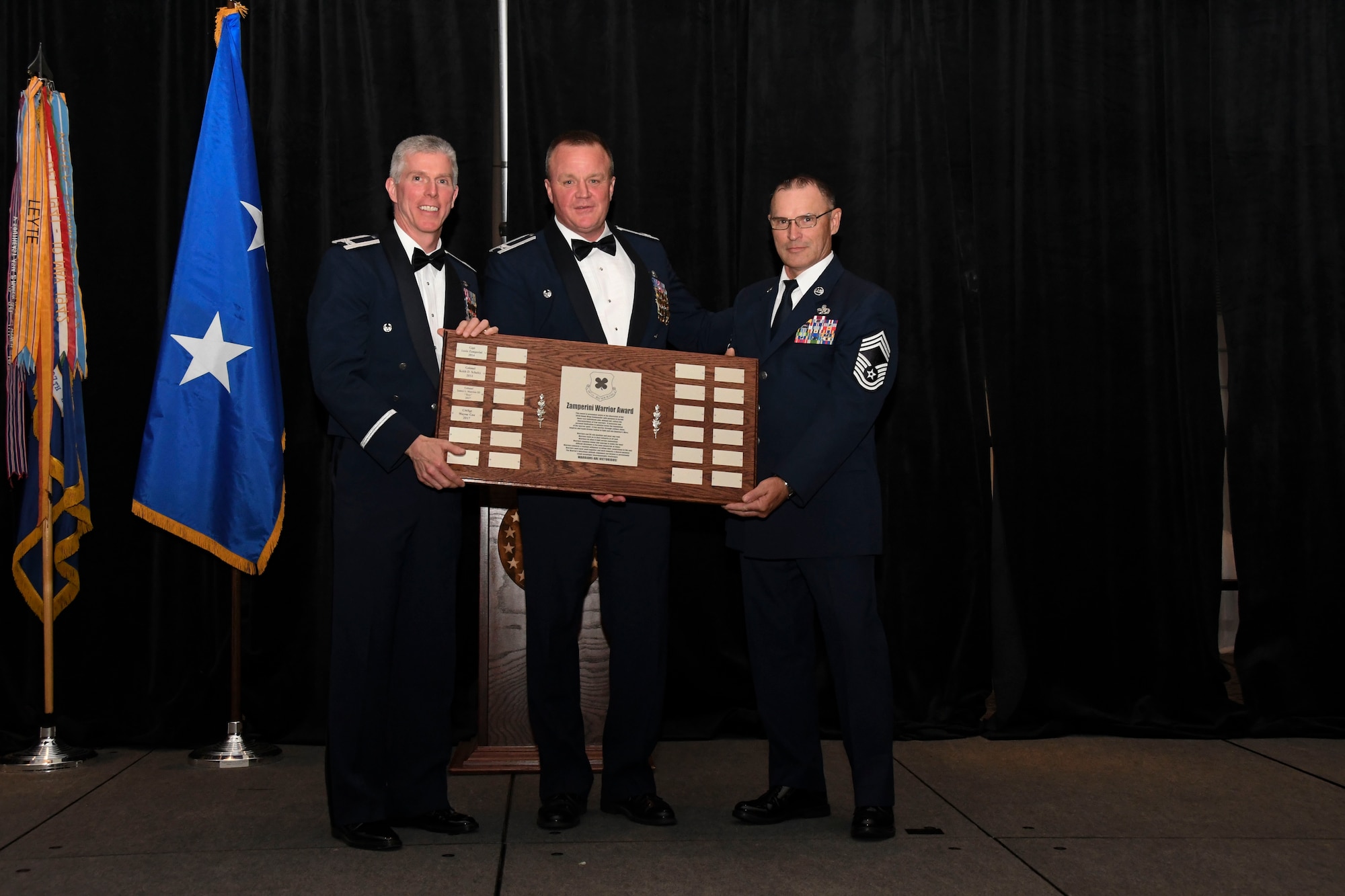 Col. Bruce R. Cox, 307th Bomb Wing commander, presents Col. James Morriss, 307th Bomb Wing vice commander, and Chief Master Sgt. Vernon Cox, 307th Maintenance Group, with the Zamperini Warrior Award during the 307th Bomb Wing’s 75th Anniversary and Awards Gala at the Shreveport Convention Center April 1, 2017. (U.S. Air Force photo by Staff Sgt. Callie Ware/Released)