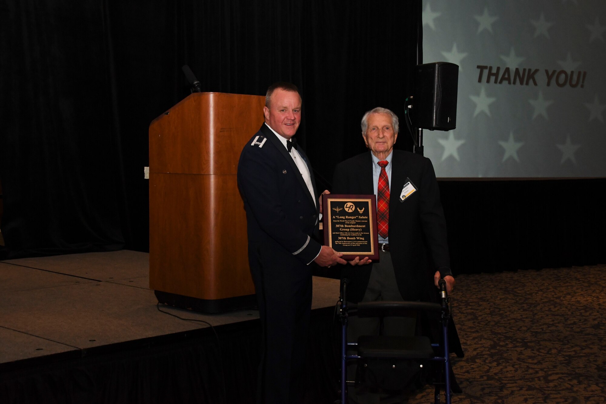 Col. Bruce R. Cox, 307th Bomb Wing commander, is presented a plaque by John Palmer, World War II 307th Bombardment Group veteran, from the 307th Bombardment Group alumni during the 307th Bomb Wing’s 75th Anniversary and Awards Gala at the Shreveport Convention Center April 1, 2017. The reunion honored all past alumni of the 307th Bombardment Group and current 307th Bomb Wing members and showcased the history of the wing since its inception during World War II. (U.S. Air Force photo by Staff Sgt. Callie Ware/Released)