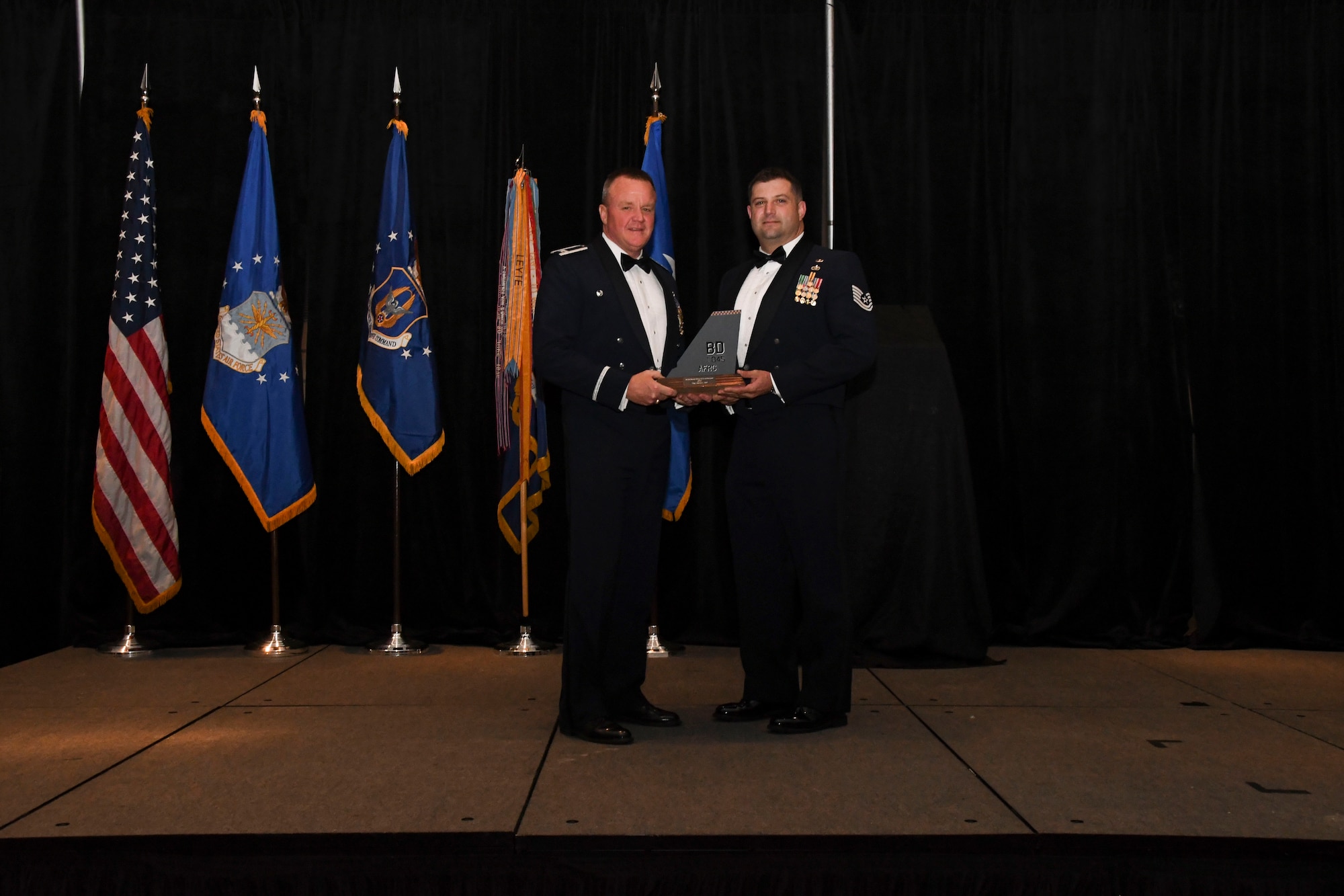 Col. Bruce R. Cox, 307th Bomb Wing commander, presents Tech. Sgt. Marvin Bell, 307th Operations Support Squadron, the 307th Bomb Wing’s Non-Commissioned Officer of the Year award for 2016. The award was presented during the 307th Bomb Wing’s 75th Anniversary and Awards Gala at the Shreveport Convention Center April 1, 2017. (U.S. Air Force photo by Staff Sgt. Callie Ware/Released)