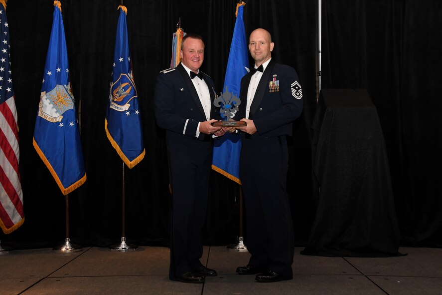 Col. Bruce R. Cox, 307th Bomb Wing commander, presents Senior Master Sgt. Frank Kuba, 707th Maintenance Squadron, the 307th Bomb Wing’s First Sergeant of the Year award for 2016. The award was presented during the 307th Bomb Wing’s 75th Anniversary and Awards Gala at the Shreveport Convention Center April 1, 2017. (U.S. Air Force photo by Staff Sgt. Callie Ware/Released)