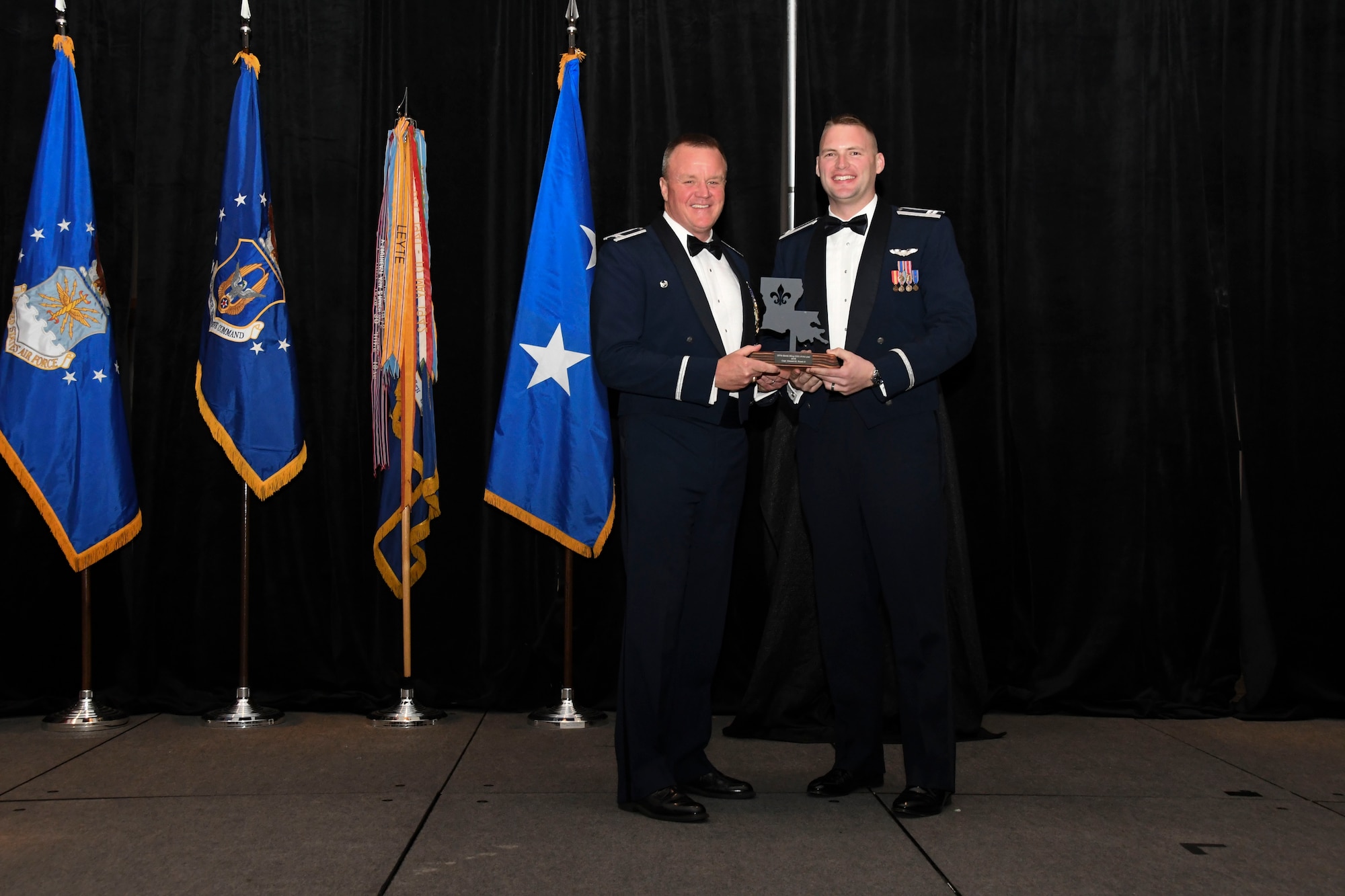 Col. Bruce R. Cox, 307th Bomb Wing commander, presents Capt. Edward Rowe, 343rd Bomb Squadron, the 307th Bomb Wing’s Company Grade Officer of the Year award for 2016. The award was presented during the 307th Bomb Wing’s 75th Anniversary and Awards Gala at the Shreveport Convention Center April 1, 2017. (U.S. Air Force photo by Staff Sgt. Callie Ware/Released)