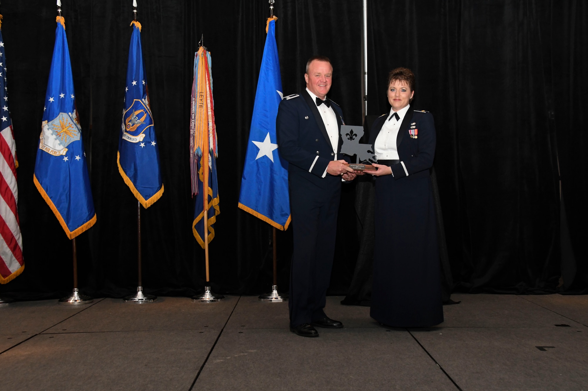 Col. Bruce R. Cox, the 307th Bomb Wing commander, presents Maj. Misty Bartley, 489th Bomb Group, the 307th Bomb Wing’s Field Grade Officer of the Year award for 2016. The award was presented during the 307th Bomb Wing’s 75th Anniversary and Awards Gala at the Shreveport Convention Center April 1, 2017. (U.S. Air Force photo by Staff Sgt. Callie Ware/Released)