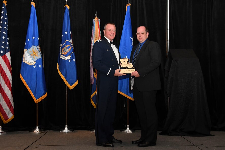 Col. Bruce R. Cox, the 307th Bomb Wing commander, presents Dwayne Richards, 307th Force Support Squadron, the 307th Bomb Wing’s Civilian of the Year award for 2016. The award was presented during the 307th Bomb Wing’s 75th Anniversary and Awards Gala at the Shreveport Convention Center April 1, 2017. (U.S. Air Force photo by Staff Sgt. Callie Ware/Released)
