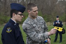 Staff Sgt. Corey Ormsby, 375th Security Forces Member, demonstrates how the laser site on a taser works for Alex a Junior Reserve Officer Training Corps member during a visit at Scott Air Force Base, Illinois, March 28, 2017. Junior ROTC members were shown how tasers are used to subdue suspects and were given a demonstration of the effects of being hit by one. (U.S. Air Force photo by Tech. Sgt. Jonathan Fowler)
