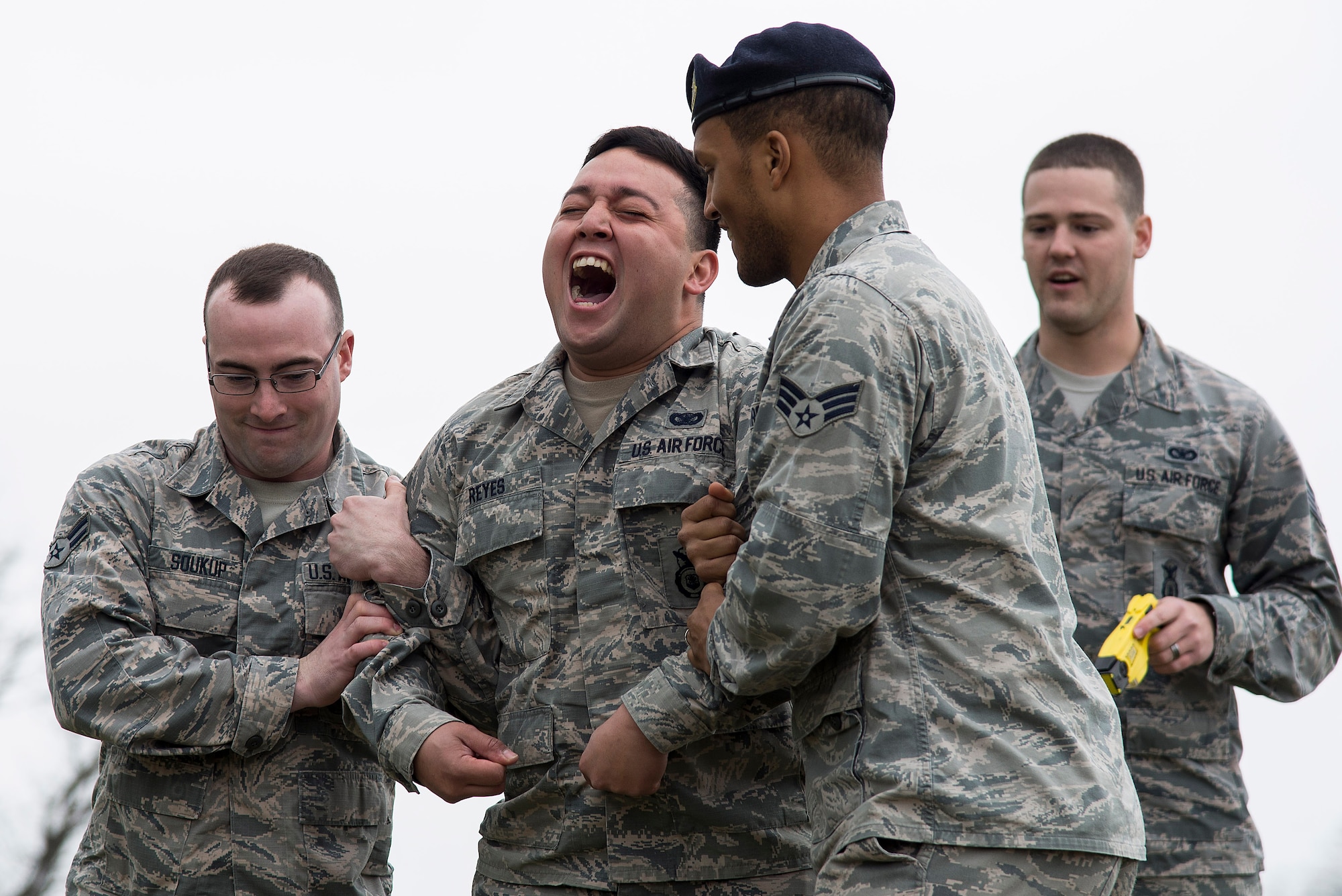 Senior Airman Leonardo Reyes Jr. (center), yells in pain while being tased during a demonstration for Junior Reserve Officer Training Corps members at Scott Air Force Base, Illinois, March 28, 2017. Reyes volunteered to be tased so that the JROTC members could see the effects of a taser and how they can be used to subdue an individual. (U.S. Air Force photo by Tech. Sgt. Jonathan Fowler)