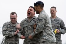 Senior Airman Leonardo Reyes Jr. (center), yells in pain while being tased during a demonstration for Junior Reserve Officer Training Corps members at Scott Air Force Base, Illinois, March 28, 2017. Reyes volunteered to be tased so that the JROTC members could see the effects of a taser and how they can be used to subdue an individual. (U.S. Air Force photo by Tech. Sgt. Jonathan Fowler)