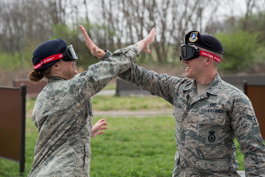 Senior Airman Taylor Pitts and Airman 1st Class Christopher Keller, both 375th Security Forces Squadron, attempt to high five while wearing ‘drunk goggles’ at Scott Air Force Base, Illinois, March 28, 2017. ‘Drunk Goggles’ are used to demonstrate various levels of alcohol impairment which allows SF members to showcase how they are able to determine if an individual is intoxicated. Pitts and Keller used them to demonstrate for Junior Reserve Officer Training Corps members how being intoxicated can make simple actions, such as a high five, more difficult. (U.S. Air Force photo by Tech. Sgt. Jonathan Fowler)