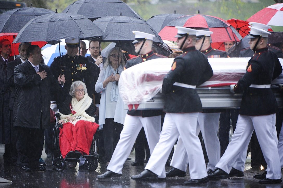 Annie Glenn, seated, widow of John Glenn, watches as Marines  assigned to Marine Barracks Washington, carry her husband's casket  the caisson to his grave in Section 35 of Arlington National Cemetery during an interment ceremony, April 6, 2017, in Arlington, Va. Glenn, the first American astronaut to orbit the Earth, and later a United States senator, died at the age of 95 on Dec. 8, 2016. Army photo by Rachel Larue 