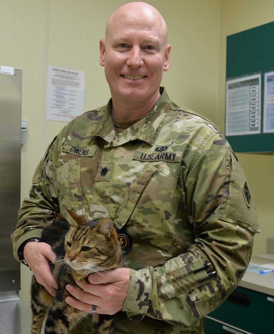 Lt. Col. Douglas Owens, U.S. Army Medical Department Center and School Department of Veterinary Science Animal Health Branch chief, poses with Steve, a domestic shorthair cat, at the AMEDDC&S Veterinary Training Center, Animal Health Branch, at Joint Base San Antonio-Fort Sam Houston. Steve is one of several retiring government-owned animals, dogs and cats, who are being put up for adoption so they can be placed in a new home.