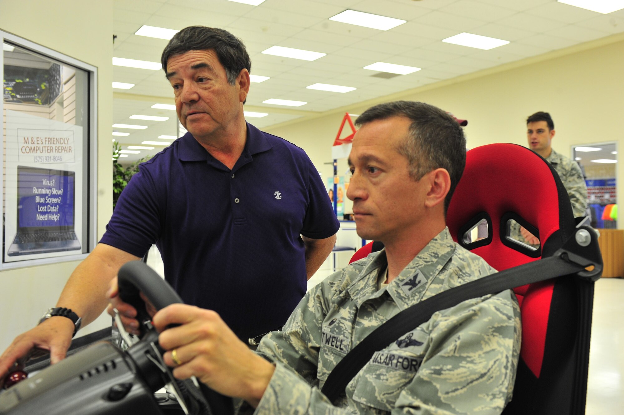 Col. Houston Cantwell, 49th Wing commander, tries out a safe driving simulator with Dan Salinas, a 49th Wing occupational safety technician, during a Distracted Driving Campaign at Holloman Air Force Base, N.M. on April 5, 2017. The simulator is a part of Distracted Driver Awareness Month, a Holloman initiative which promotes safe driving around base. (U.S. Air Force photo by Staff Sgt. Warren Spearman)