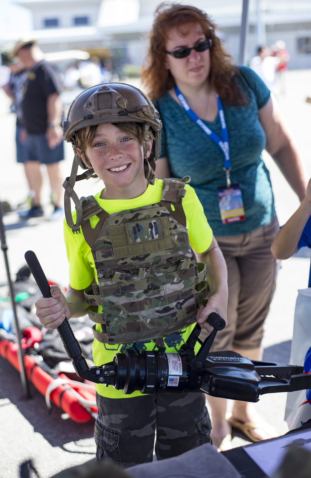 A visitor poses with a helmet, body armor and a hydraulic rescue tool during the Melbourne Air & Space Show April 1, 2017, at Melbourne, Fla. Airmen from the 920th Rescue Wing displayed the helicopter and equipment used to accomplish the combat search-and-rescue mission. The airshow attracted more than 10,000 participants and showcased both military and civilian aircraft. (U.S. Air Force photo/Staff Sgt. Jared Trimarchi)