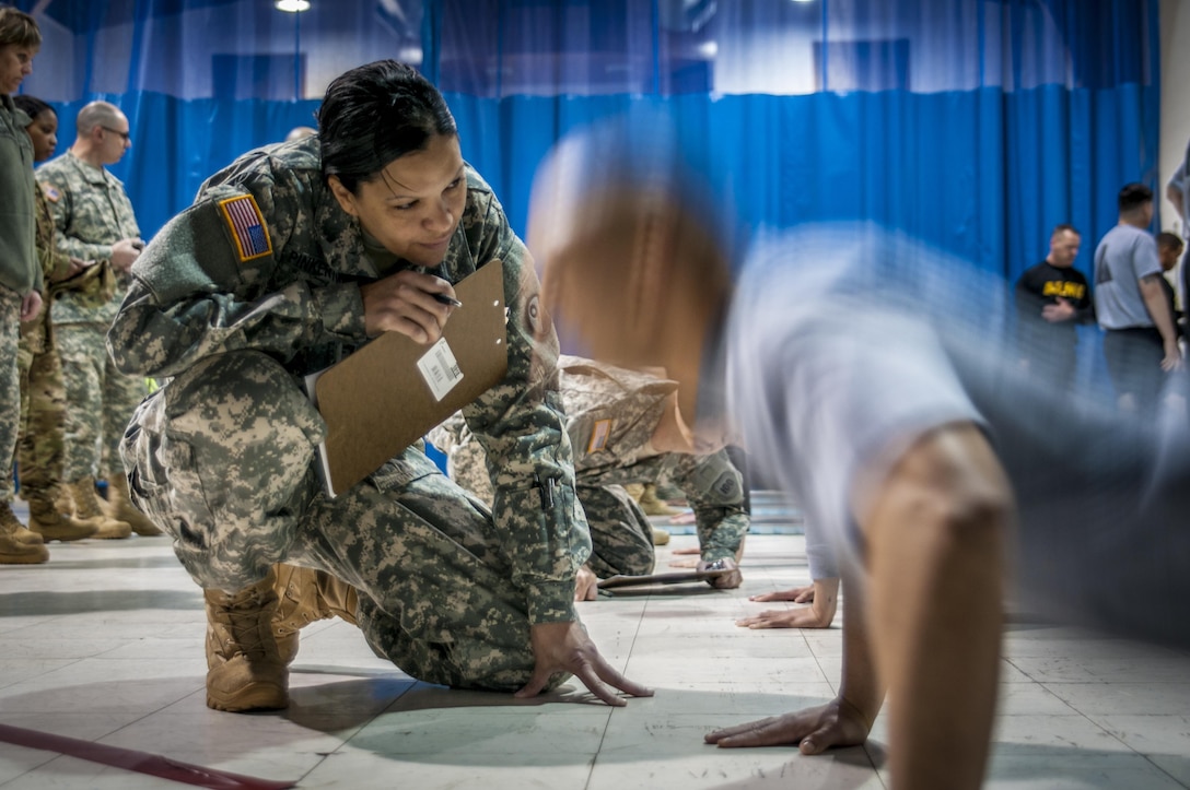 Master Sgt. Rosie Pinkerton, counts a competitor's pushups during the Army Physical Fitness Test during the 80th Training Command and 99th Regional Support Command's combined Best Warrior Competition at Fort Devens, Massachusetts April, 3, 2017.