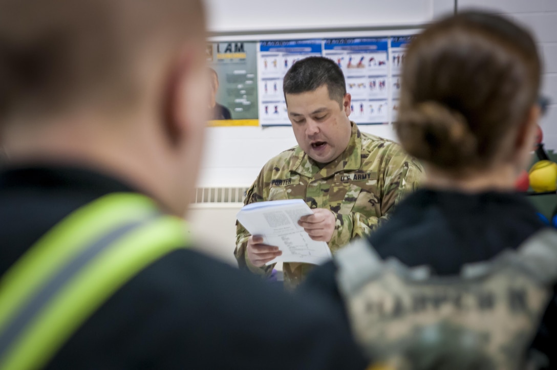 Sergeant 1st Class Gregory Porter reads the instructions for the two-mile run portion of the Army Physical Fitness Test during the 80th Training Command and 99th Regional Support Command's combined Best Warrior Competition at Fort Devens, Massachusetts April, 3, 2017.