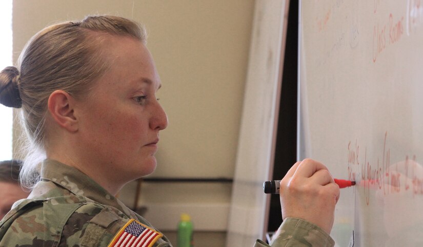 Capt. Amber Grimsley, commander of the 369th Transportation Company out of Wichita, Kan., writes down the plan of action for an  emergency response scenario as part of the Defense Support of Civil Authorities workshop held in Belton, Mo., on April 2, 2017. (U.S. Army Reserve photo by Spc. Christopher A. Hernandez, 345th Public Affairs Detachment)