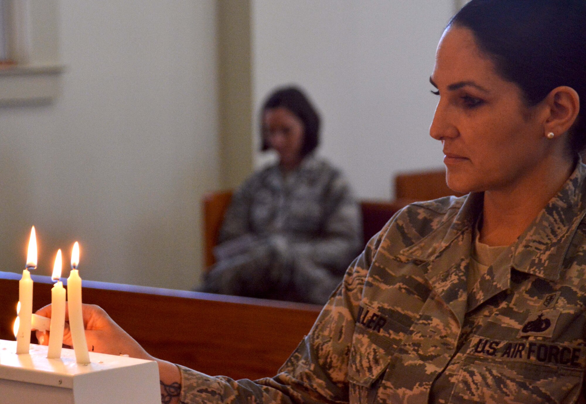 NAVAL AIR STATION FORT WORTH JOINT RESERVE BASE, Texas -- Staff Sgt. Stephanie Miller, a 301st Fighter Wing mental health technician, lights a candle during the 8th Annual Candlelight Vigil at the base chapel, April 6, 2017, in a show of support for National Crimes Victims’ Rights Week. Members of the wing participated in the vigil to help raise awareness of crime victims’ rights, while honoring them and those who advocate on their behalf. (U.S. Air Force photo by Staff Sgt. Samantha Mathison)