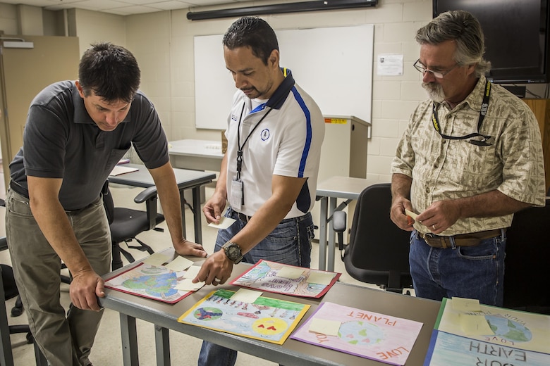 Judges critique the Laurel Bay schools Earth Day posters aboard Marine Corps Air Station Beaufort, April 4. The Natural Resources and Environmental Affairs Office holds the contest in the schools annually to promote healthy environmental management at an early age. The environmental specialists are with NREAO, MCAS Beaufort.