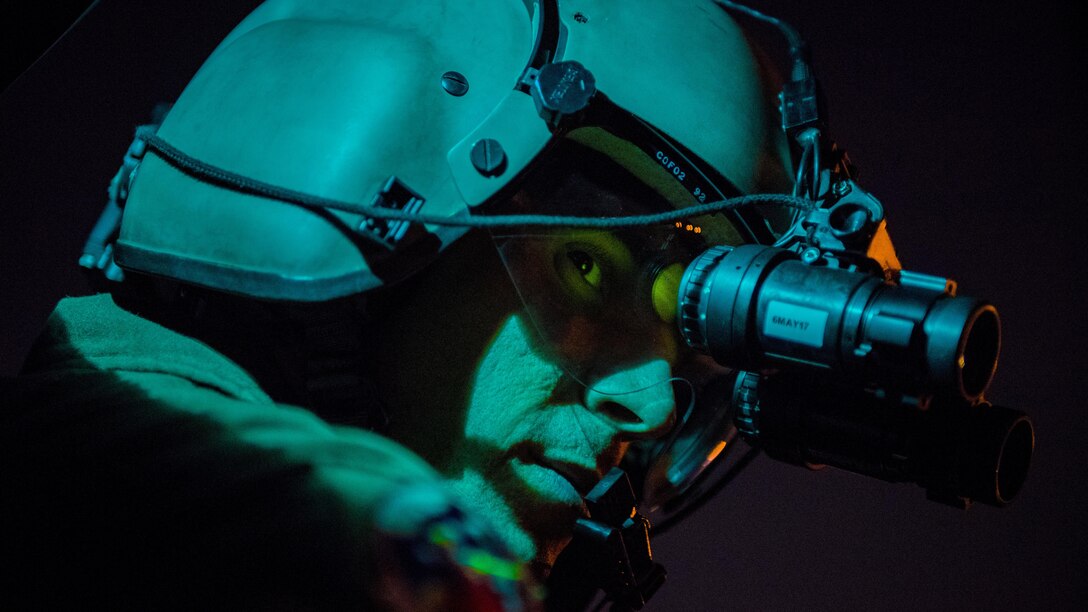 Air Force Staff Sgt. Nicholas A. Poe looks through night-vision goggles out the window of a UH-N1 helicopter during a night-hoist training in Tokyo, April 4, 2017. Poe is a special missions aviator assigned to the 459th Airlift Squadron. Air Force photo by Airman 1st Class Donald Hudson
