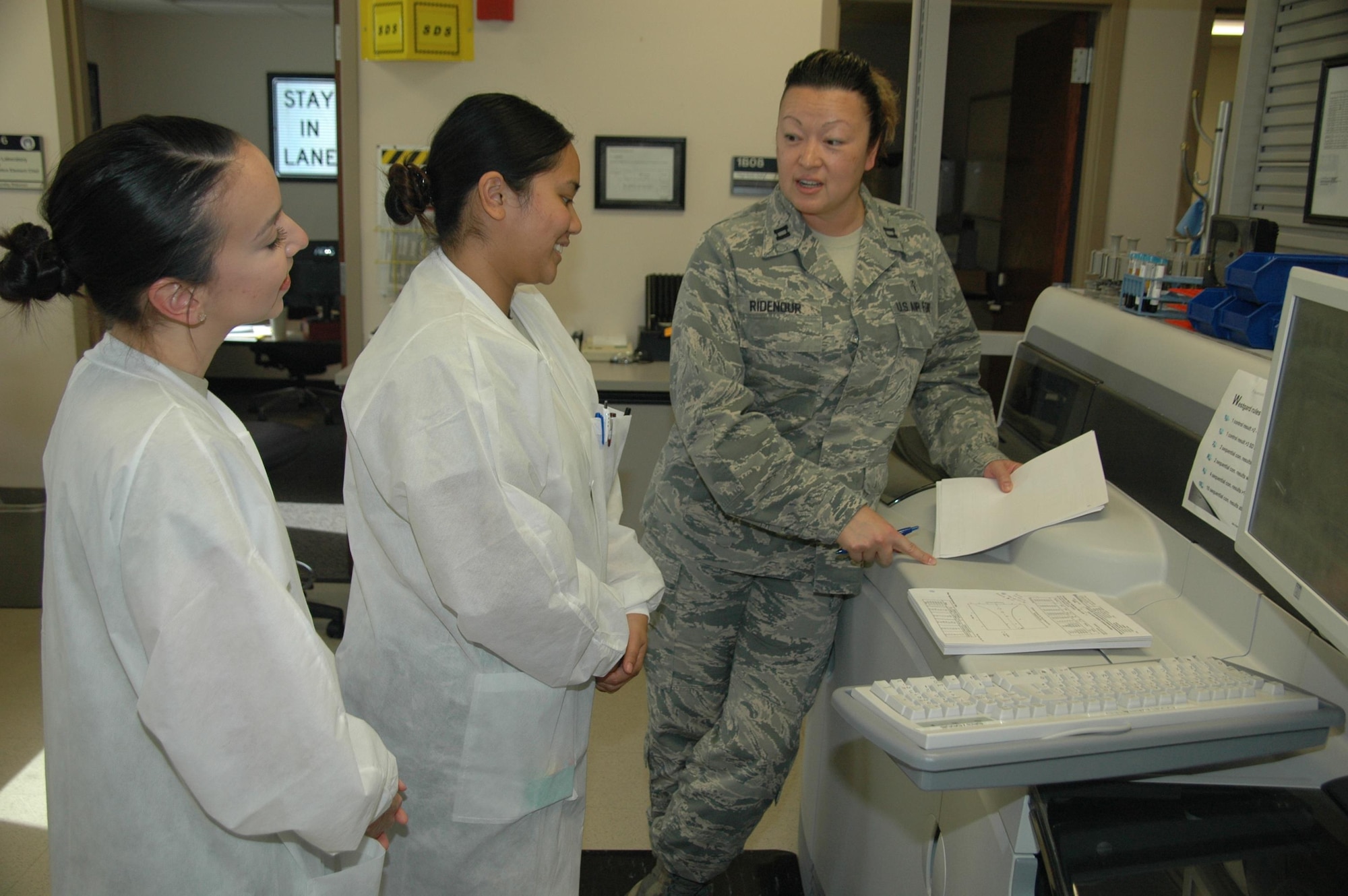 Capt. Dorothy Ridenour, chief of the 61st Medical Squadron’s Diagnostic Element at Los Angeles Air Force Base in El Segundo, California, shares the results of chemistry linearity studies from the College of American Pathologists to Staff Sgt. Laurie-Mhae Turla, center, and Senior Airman Jennifer Toney, 61st MDS medical laboratory technicians. The 61st MDS laboratory recently passed a no-notice inspection from the leading organization of board-certified pathologists. The CAP inspector stated it was the highest performing lab ever seen, rating it in the top one-half percent of all labs nationally. (U.S. Air Force photo / Jim Spellman)