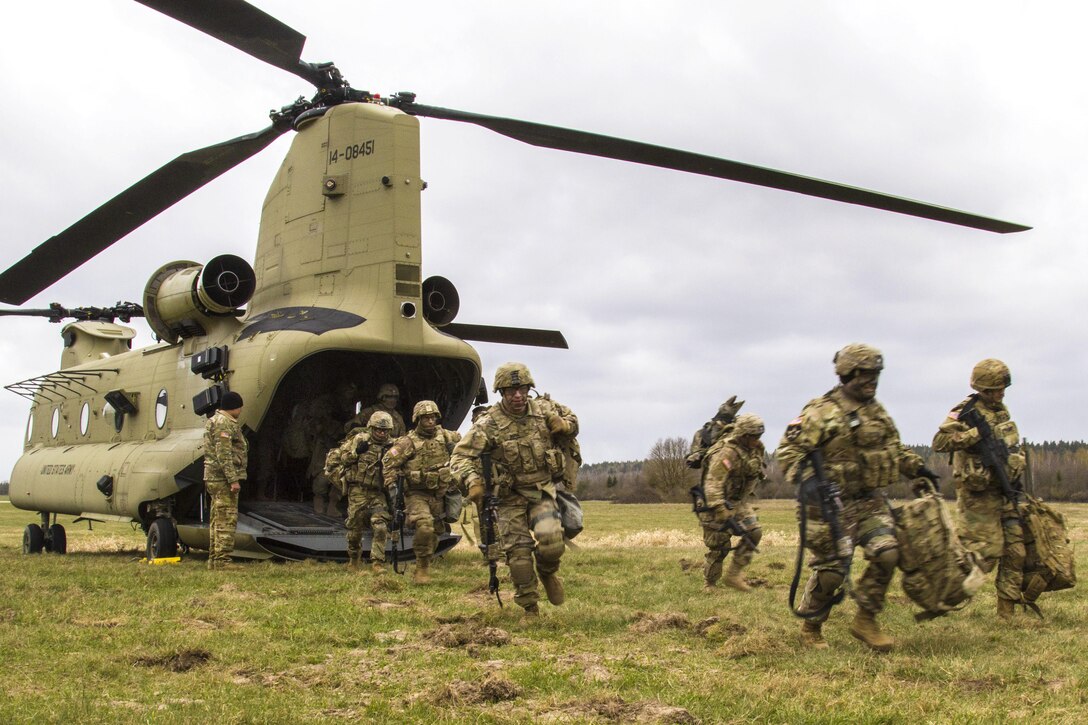 Soldiers exit a CH-47 Chinook helicopter during a training exercise at Grafenwoehr Training Area, Germany, April 6, 2017. Soldiers and aviators benefit from training together, which increases their knowledge and understanding of each other's roles. The soldiers are assigned to 3rd Squadron, 2nd Cavalry Regiment. Army photo by Spc. Thomas Scaggs