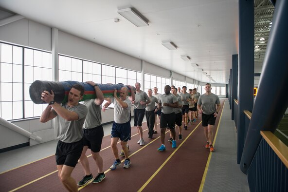 U.S. Air Force Tactical Air Control Party Airmen assigned to Detachment 1, 3rd Air Support Operations Squadron, run with Chief Master Sgt. Brent Sheehan, the 354th Fighter Wing command chief, while carrying a log March 31, 2017, at the Baker Field House on Eielson Air Force Base, Alaska. The log represents the burden these Airmen carry for their fallen brethren. (U.S. Air Force photo by Airman 1st Class Isaac Johnson)