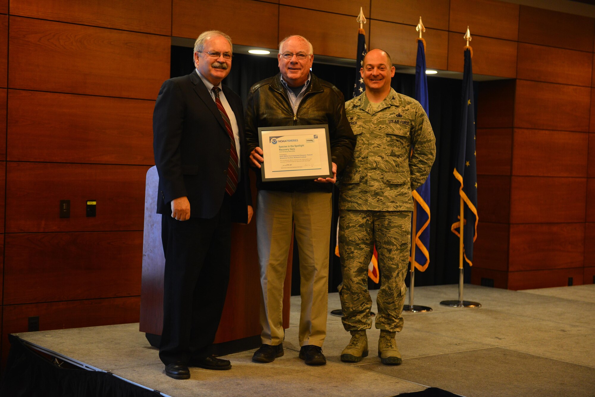 Doug Mecum, Deputy Regional Administrator for the National Oceanic and Atmospheric Association Fisheries in Alaska and Air Force Col. George T.M. Dietrich III, the JBER commander and 673d Air Base Wing commander awards Richard Graham, with the 673d Civil Engineer Squadron a plaque in recognition of JBER being the NOAA’s Species in the Spotlight Recovery Hero. NOAA chose to recognize JBER first because of the effectiveness of their ongoing partnership over the past thirty years.