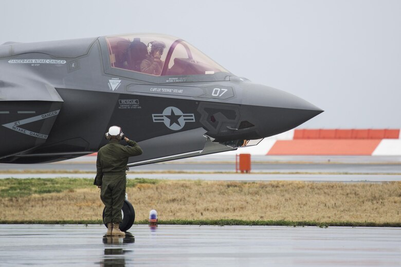 A U.S. Marine with Marine Fighter Attack Squadron (VMFA) 121 salutes a pilot during hot-reload training at Marine Corps Air Station Iwakuni, Japan, April 6, 2017. This signified the first time the squadron loaded ordnance onto a running F-35B Lightning II aircraft at the air station in order to prepare for real-world scenarios. (U.S. Marine Corps photo by Lance Cpl. Joseph Abrego)