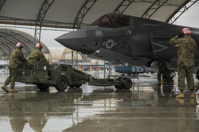U.S. Marines with Marine Fighter Attack Squadron (VMFA) 121 load ordnance on an F-35B Lightning II aircraft during hot-reload training at Marine Corps Air Station Iwakuni, Japan, April 6, 2017. This signified the first time the squadron loaded ordnance onto a running F-35B Lightning II aircraft at the air station in order to prepare for real-world scenarios. (U.S. Marine Corps photo by Lance Cpl. Joseph Abrego)
