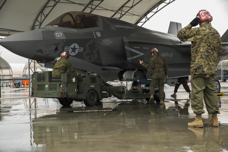 U.S. Marines with Marine Fighter Attack Squadron (VMFA) 121 load ordnance on an F-35B Lightning II aircraft during hot-reload training at Marine Corps Air Station Iwakuni, Japan, April 6, 2017. This signified the first time the squadron loaded ordnance onto a running F-35B Lightning II aircraft at the air station in order to prepare for real-world scenarios. (U.S. Marine Corps photo by Lance Cpl. Joseph Abrego)