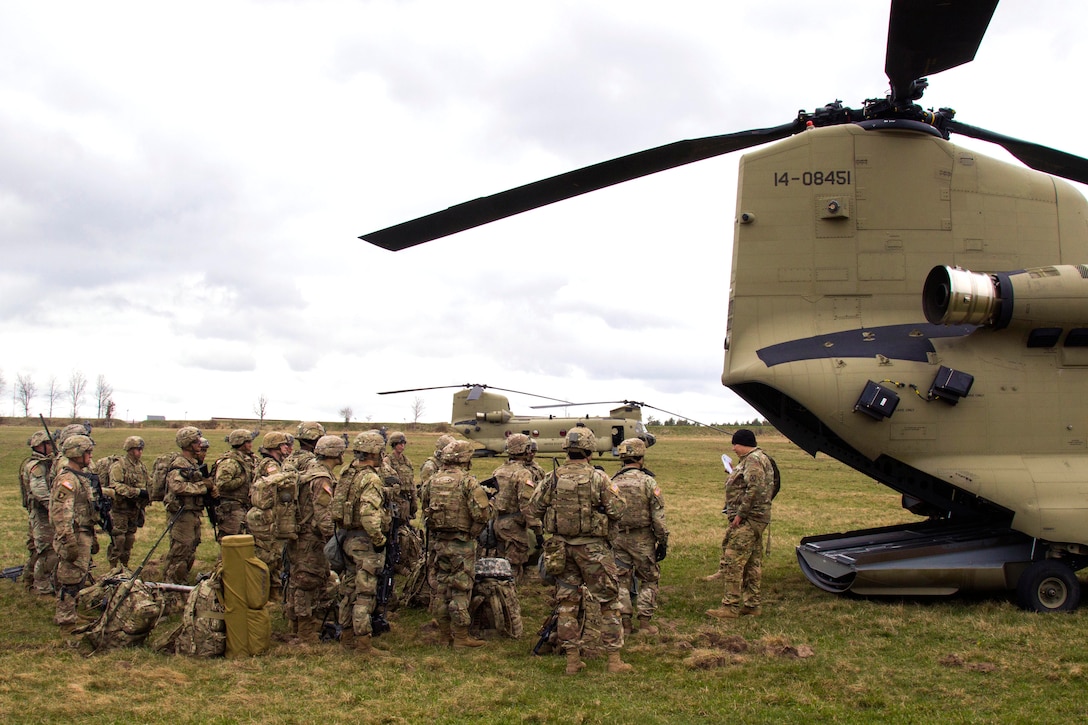 Army Spc. Fernando Padilla, right, gives a mission brief to soldiers before participating in air assault training at Grafenwoehr Training Area, Germany, April 6, 2017. Padilla is a flight engineer assigned to Company B, 3rd Battalion, 10th General Support Aviation Battalion. Army photo by Spc. Thomas Scaggs