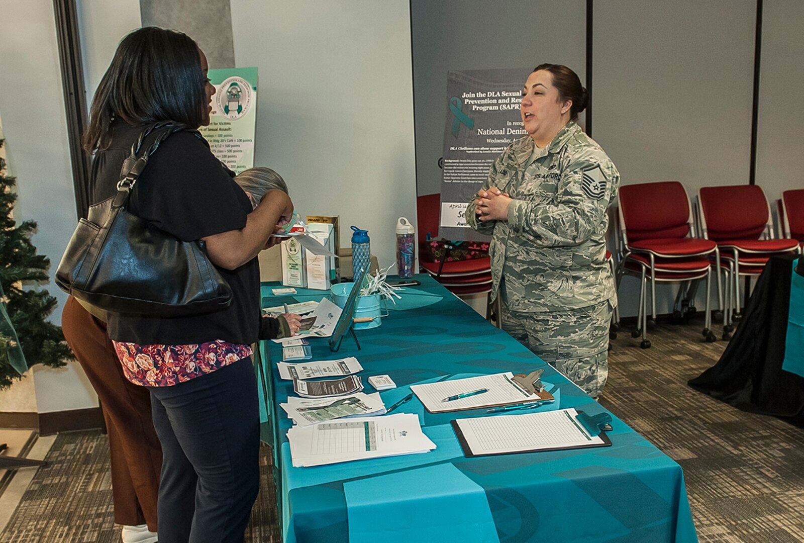 Air Force Master Sgt. Maggie Ladd (right) speaks to fellow associates during the Sexual Assault Awareness and Prevention Month information fair April 5 at Defense Supply Center Columbus. The fair promoted sexual assault prevention resources and announced activities taking place throughout the month in support of SAAPM.