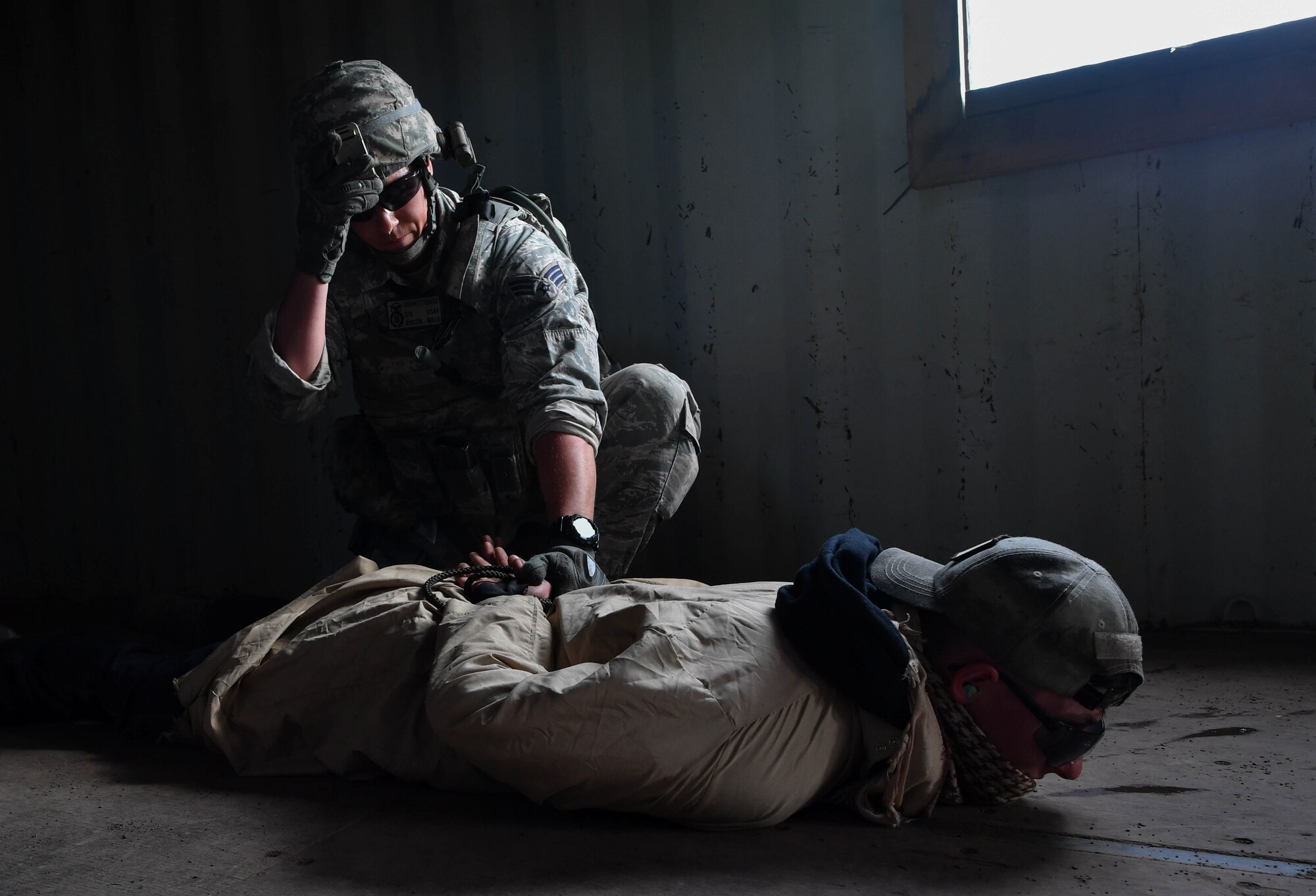 Senior Airman Austin Mills, 569th U.S. Forces Police Squadron patrolman, apprehends a simulated opposing force personnel during the urban operations portion of the 435th Security Forces Squadron’s Ground Combat Readiness Training Center’s Security Operations Course on U.S. Army Garrison Baumholder, Germany, April 4, 2017. While conducting a mission to gain intelligence from a simulated foreign village leader, Mills and other students were attacked by cadres in the role of opposing forces with blank rounds and flash bangs. Airmen assigned to the 86th SFS, 422nd SFS, 100th SFS, and 569th USFPS participated in the course. (U.S. Air Force photo by Senior Airman Tryphena Mayhugh)