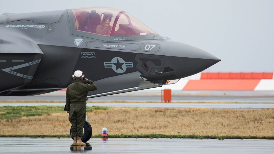 A Marine with Marine Fighter Attack Squadron (VMFA) 121 salutes a pilot during hot-reload training at Marine Corps Air Station Iwakuni, Japan, April 6, 2017. This signified the first time the squadron loaded ordnance onto a running F-35B Lightning II aircraft at the air station in order to prepare for real-world scenarios. 