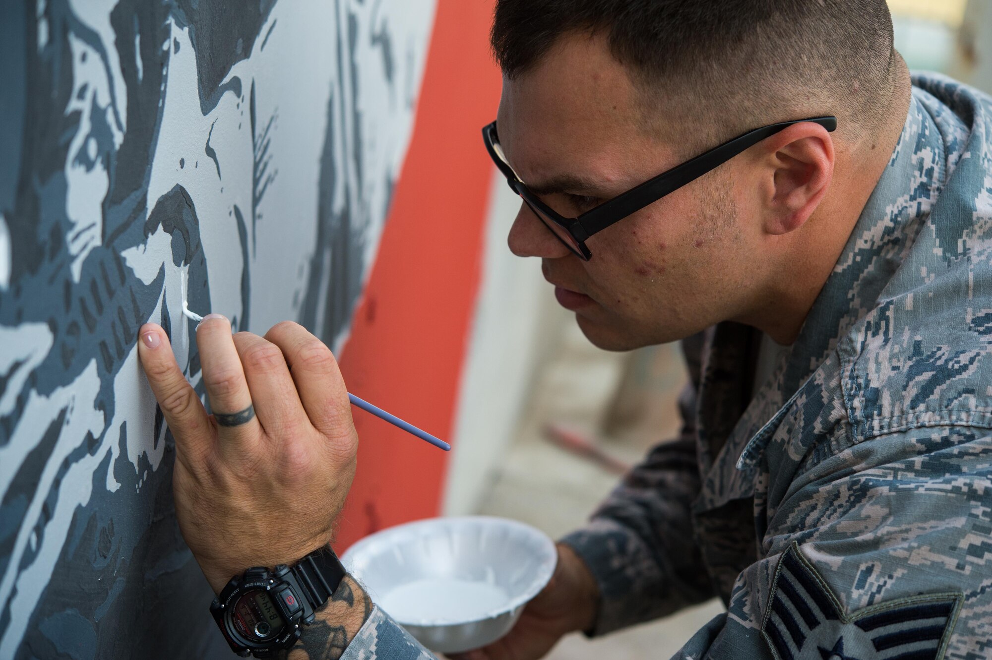 Staff Sgt. Jonathan, a 380th Expeditionary Civil Engineer Squadron firefighter, paints the final touches on a mural at an undisclosed location in Southwest Asia, March 6, 2017. Johnathan dedicated more than 150 hours during his off-duty time to complete the mural while supporting Combined Joint Task Force-Operation Inherent Resolve. (U.S. Air Force photo/Senior Airman Tyler Woodward)