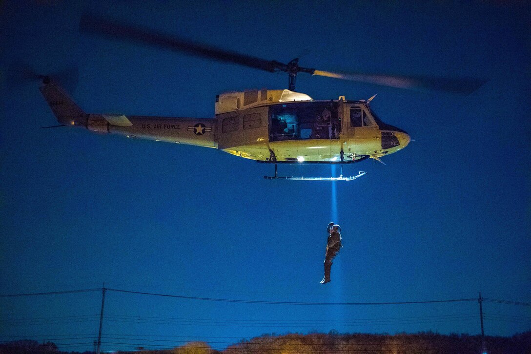 Air Force Capt. Lance M. Stafford is lifted into UH-1N Iroquois helicopter during a night-hoist training exercise at Yakota Air Base, Japan, April 4, 2017. Stafford is a pilot assigned to the 36th Airlift Squadron. Air Force photo by Airman 1st Class Donald Hudson 