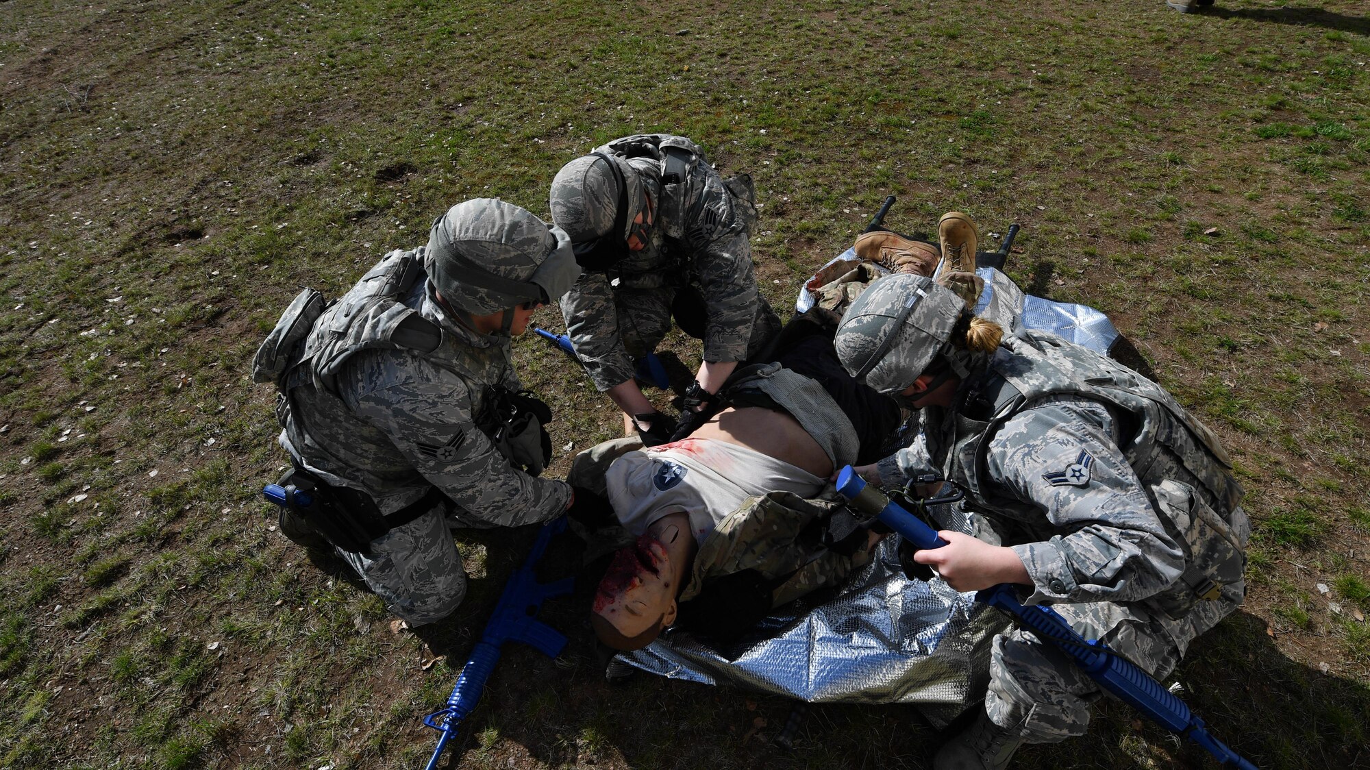 Students of the 435th Security Forces Squadron’s Ground Combat Readiness Training Center’s Security Operations Course give aid to a simulated injured Airman during the tactical combat casualty care portion of the course on Ramstein Air Base, Germany, March 30, 2017. The students provided medical care, called for a medical evacuation, moved the dummy onto a litter, and carried it to a simulated helicopter while an instructor monitored their actions. Airmen assigned to the 86th SFS, 422nd SFS, 100th SFS, and 569th U.S. Forces Police Squadron participated in the course. (U.S. Air Force photo by Senior Airman Tryphena Mayhugh)