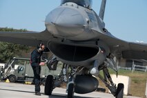 U.S. Air Force Staff Sgt. Eric Maxwell, 52nd Aircraft Maintenance Squadron dedicated crew chief checks the intake of the jet engine of an F-16 Fighting Falcon during a “hot pit” at Spangdahlem Air Base, Germany, March 28, 2017. A “hot pit” is the refueling of an aircraft while its engine is still running. During the refueling process, the aircraft is checked for safety items such as leaks and debris before returning to the air. (U.S. Air Force photo by Airman 1st Class Preston Cherry)