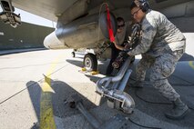 U.S. Air Force Airman 1st Class Matt Mac Rae, left, 52nd Aircraft Maintenance Squadron aircraft electrical and environmental technician, and Airman 1st Class Tyler Shirk, right, 52nd Logistics Readiness Squadron fuels distribution operator, move a Type-4 hydrant system hose after refueling an F-16 Fighting Falcon during a “hot pit” at Spangdahlem Air Base, Germany, March 28, 2017. An aircraft’s engine stays running during a “hot pit” allowing approximately 1,300 gallons of fuel to be administered 30% faster than a typical refueling process. (U.S. Air Force photo by Airman 1st Class Preston Cherry)
