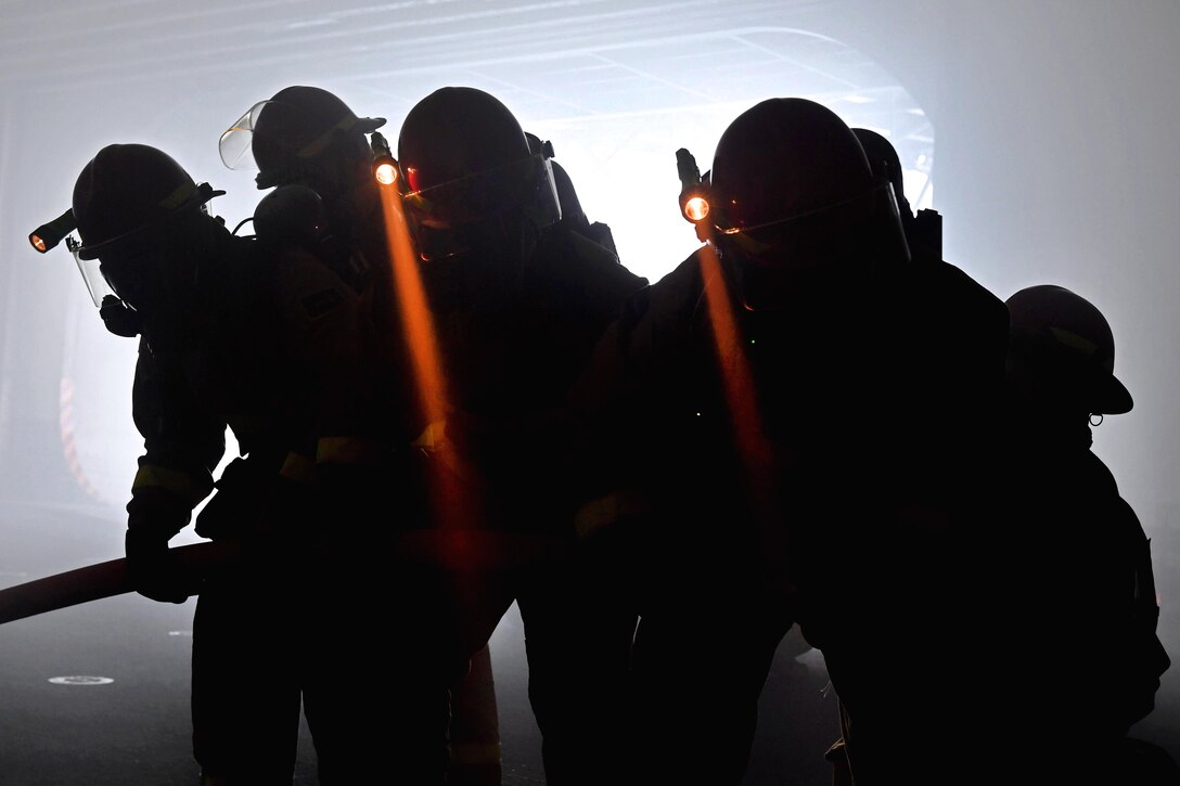 Sailors conduct firefighting training during a drill in the hangar bay aboard amphibious assault ship USS America in the Pacific Ocean, March 30, 2017. Navy photo by Petty Officer 2nd Class Ramon Go