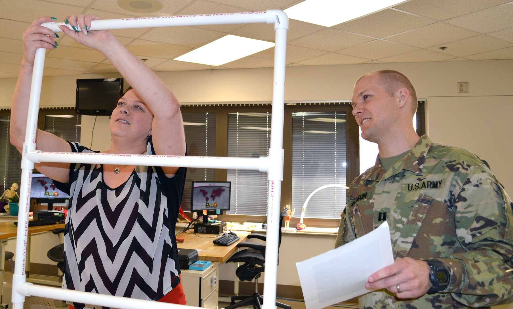 Army Capt. Matthew Baumann (right), registered occupational therapist, watches as Allissa Surran puts plastic piping together in the BAMC Outpatient Occupational Therapy Clinic March 27. Hand function encompasses a host of different areas such as: strength, sensation, endurance, range of motion, dexterity, visual acuity, cognition, etc. Activities such as this allow professionals to note one’s dominant and nondominant hand performance, and determine how an individual’s hand function is affected.