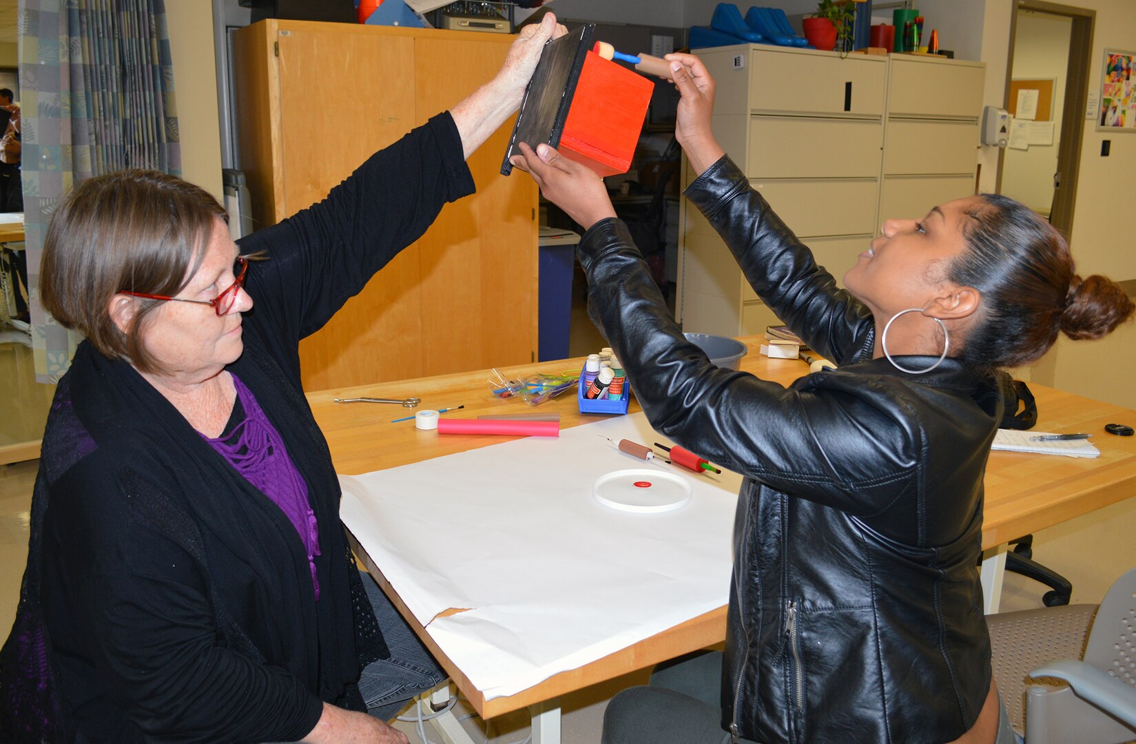 Linda Voronin (right), certified occupational therapy assistant, works with Velicia Siggers on a functional activity March 27 at the BAMC Outpatient Occupational Therapy Clinic. Occupational therapy centers on the targeted use of activities (like painting a bird house) to increase individual overall functioning.  Occupational therapy believes that it’s not enough to only increase an individual’s strength or endurance; rather, it’s more important to allow an individual to get back to engaging in personally-meaningful activities.
